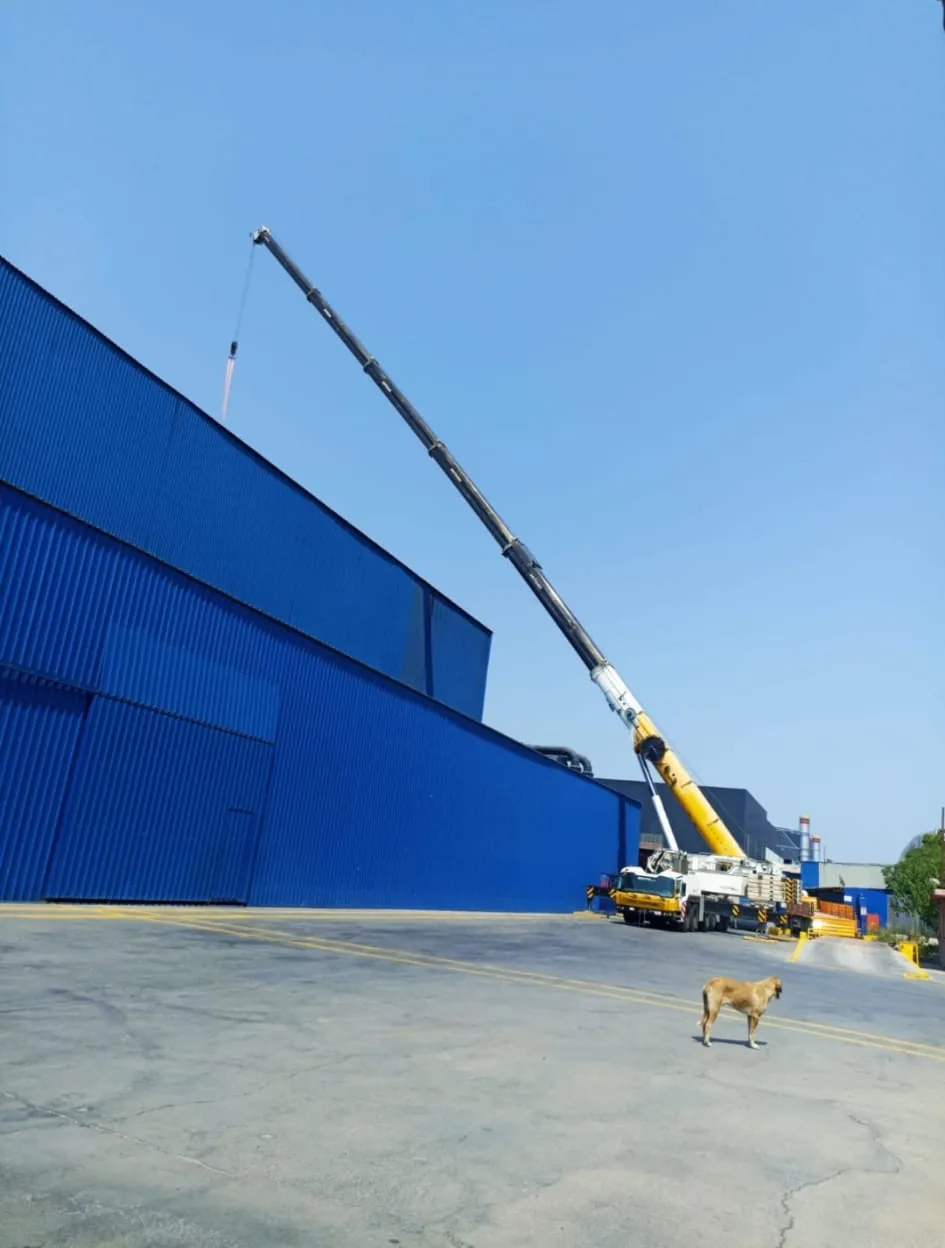 Fırın montajı çalışmasında fabrika çatısının üzerine uzanan mobil vinç bomu