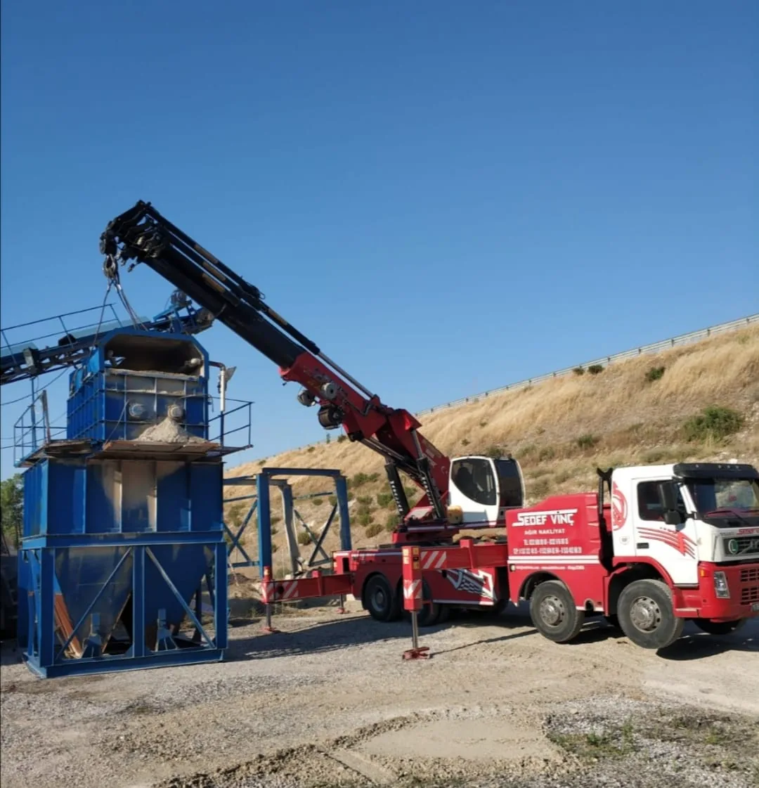 Kamyon üstü vincin mavi sanayi ekipmanında yaptığı kaldırma çalışması